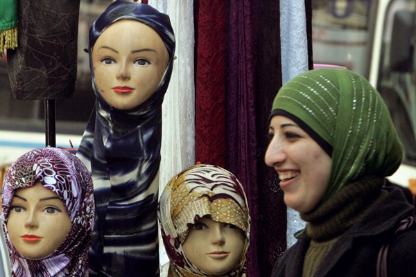 A Palestinian woman walks by a display of Islamic headscarves for sale at a shop in the West Bank city of Ramallah, Feb. 28, 2007 (AP photo by Muhammed Muheisen).