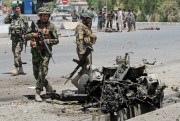 Afghan security forces inspect the site of a suicide attack in the city of Kandahar south of Kabul, Afghanistan, July 9, 2014 (AP photo by Allauddin Khan).