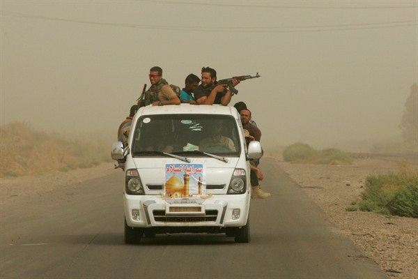 Iraqi Shiite fighters with the "Peace Brigades" patrol during a sand storm in Samarra, Iraq, July 12, 2014 (AP Photo/File).