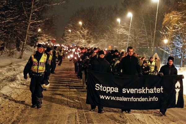 Neo-nazis, rightwing extremists and white supremacists march under police supervision on their annual demonstration in memory of a young skinhead who was killed in 2000, Dec. 11, 2010 (AP Photo by Fredrik Persson, file).