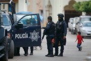 Mexican federal police stand next to their vehicle in the town of Aguililla, Mexico, July 24, 2013 (AP photo by Gustavo Aguado).
