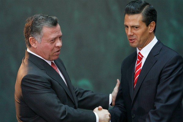 Mexican President Enrique Pena Nieto and King Abdullah II of Jordan embrace during a joint press conference at the National Palace in Mexico City, Feb. 6, 2014 (AP photo by Marco Ugarte).