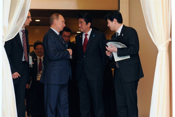Russian President Vladimir Putin speaks to Japanese Prime Minister Shinzo Abe after their talks in the Bocharov Ruchei residence in Sochi, Russia, Feb. 8, 2014 (AP photo/RIA-Novosti, Mikhail Klimentyev).
