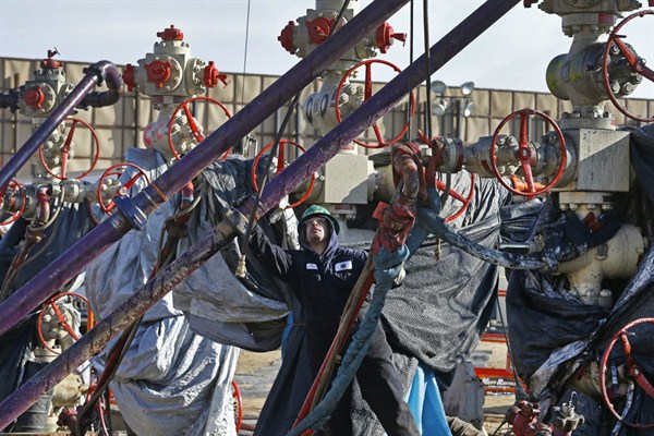 A worker adjusts pipes during a hydraulic fracturing operation at an Encana Corp. well pad near Mead, Co., March 25, 2014 (AP photo by Brennan Linsley).