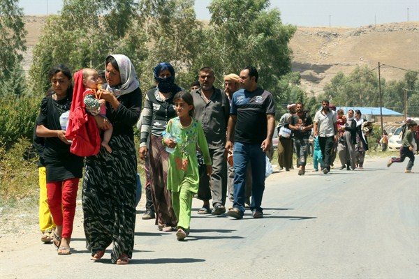 Displaced Iraqis from the Yazidi community cross the Syria-Iraq border at Feeshkhabour border point, in northern Iraq, Aug. 10, 2014 (AP photo by Khalid Mohammed).