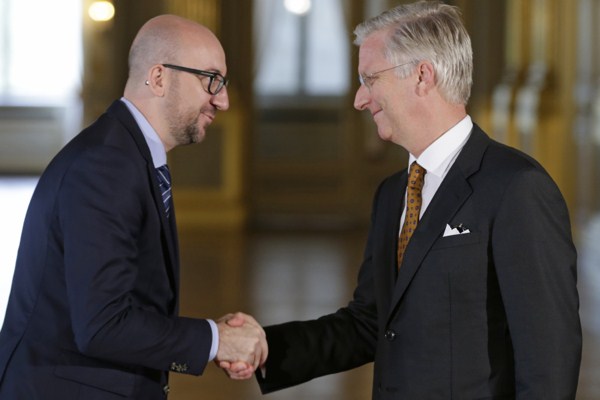 Belgium’s Prime Minister Charles Michel, left, takes the oath during a swearing-in ceremony with Belgian King Philippe at the Royal Palace in Brussels, Sept. 11, 2014 (AP photo by Yves Logghe).