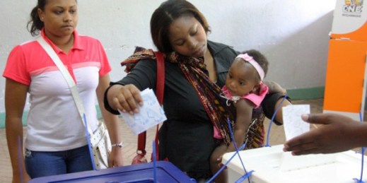 A woman holding her baby casts her vote, during municipal elections held in the city of Maputo, Mozambique, Nov. 20, 2013 (AP photo by Ferhat Momade).