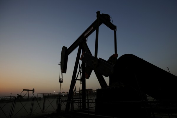 Oil pumps work at sunset in the desert oil fields of Sakhir, Bahrain, Oct. 14, 2014 (AP photo by Hasan Jamali).