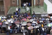 Zimbabweans queue in the rain outside immigration offices in Johannesburg as they wait to apply to become legal immigrants, Dec. 15, 2010 (AP photo by Denis Farrell).