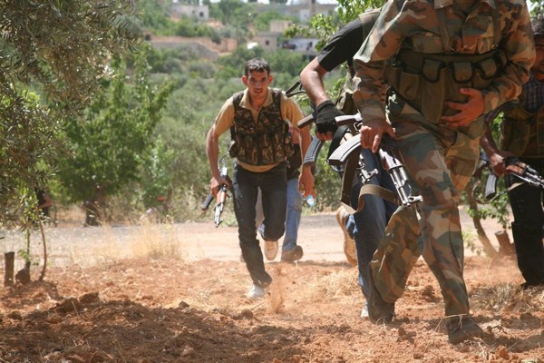 Syrian rebels from the “Al-Qasas Brigade” or “Justice Brigade” run through an olive grove to avoid Syrian Army snipers, Oct. 20, 2012 (photo by Flickr user syriafreedom licensed under the Creative Commons Attribution 2.0 Generic license).