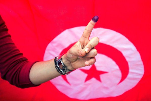 A Tunisian woman shows her ink-stained finger after voting at a polling station in Ben Arous, Tunisia, Oct. 26, 2014 (AP photo by Aimen Zine).
