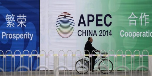 A man rides a bicycle past a billboard of APEC China 2014 with its slogans near the venues for the Asia-Pacific Economic Cooperation summit in Beijing, China, Nov. 7, 2014. (AP photo by Andy Wong).