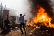 A car burns outside the parliament building in Burkina Faso as people protest against their longtime President Blaise Compaore, who seeks another term in Ouagadougou, Burkina Faso, Oct. 30, 2014 (AP photo by Theo Rena).