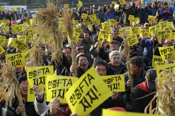 South Korean farmers hold signs reading “Block, the FTA between South Korea and China” during a rally opposing a free trade agreement with China in Seoul, South Korea, Nov. 20, 2014 (AP photo by Lee Jin-man).