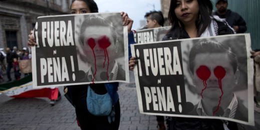 Protesters hold up posters that read in Spanish “Pena Out!” during a march to pressure the government into finding 43 missing college students, Mexico City, Nov. 20, 2014 (AP photo by Rebecca Blackwell).