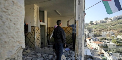 Palestinians hang a national flag from the apartment of Abdel Rahman al-Shaludi in East Jerusalem. Israeli authorities demolished it after Shaludi’s deadly attack with his car on a Jerusalem train station last month, (AP Photo/Mahmoud Illean).