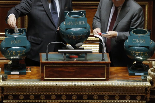 A French Senator casts his ballot in an urn supporting a motion, at left, during a vote on the recognition of a Palestinian state, at the French Senate in Paris, France, Dec. 11, 2014 (AP photo by Francois Mori).