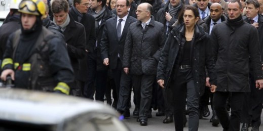 French President Francois Hollande, center left, flanked by French Interior Minister Bernard Cazeneuve, right, walks outside the French satirical newspaper Charlie Hebdo’s office, in Paris, Jan. 7, 2015 (AP photo by Remy De La Mauviniere).