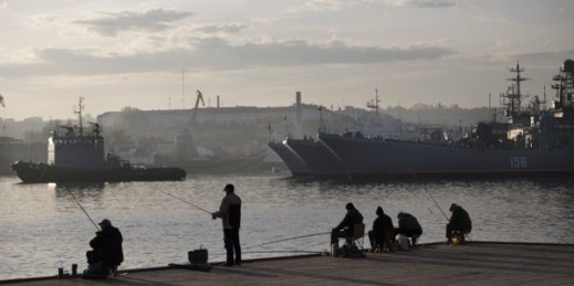Local fishermen try to catch fish in front of Russian Navy ships in Sevastopol, Crimea, Oct. 27, 2014 (AP photo by Alexander Zemlianichenko).