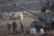 Israeli soldiers stand next to a mobile artillery unit in the Israeli-controlled Golan Heights near the border with Syria, Jan. 28, 2015 (AP photo by Ariel Schalit).