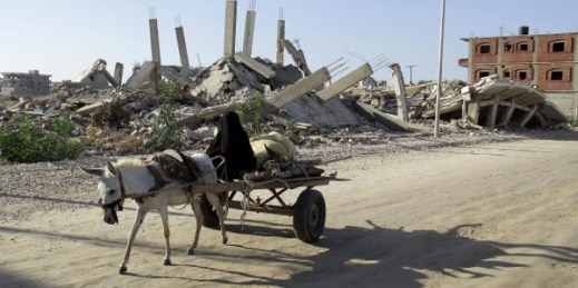 A woman maneuvers a donkey cart on a street amid debris of buildings demolished by the Egyptian army on the Egyptian side of border town of Rafah, Nov. 6, 2014 (AP Photo/El Shorouk newspaper, Ahmed Abd El-Latif).