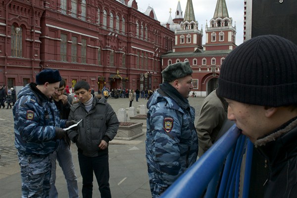 Russian police officers check the identity papers of migrant workers arriving at Red Square ahead of New Year’s Eve festivities, Moscow, Russia, Dec. 31, 2013 (AP photo by Ivan Sekretarev).