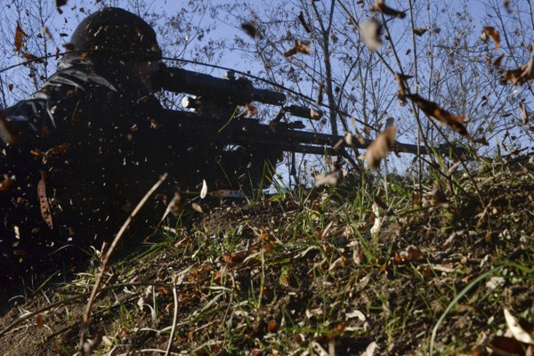 A pro-Russian rebel fires sniper rifle toward Ukrainian army positions at the frontline near Peski village, Donetsk, eastern Ukaine, Nov. 21, 2014 (AP photo by Mstyslav Chernov).