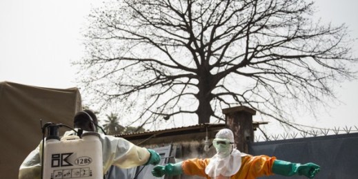 Burial teams in Guinea, wearing full personal protective equipment, disinfect themselves after carrying the body of a 40-year-old woman who died from the Ebola virus, Conakry, Guinea, Jan. 17, 2015 (U.N. photo by Martine Perret).