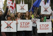 Demonstrators carry posters saying “Stop Russia!” and crossed out pictures of Russian President Vladimir Putin during a rally in Tbilisi, Georgia, Nov. 15, 2014 (AP photo by Shakh Aivazov).