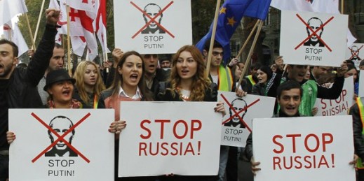 Demonstrators carry posters saying “Stop Russia!” and crossed out pictures of Russian President Vladimir Putin during a rally in Tbilisi, Georgia, Nov. 15, 2014 (AP photo by Shakh Aivazov).