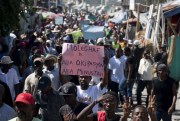 A demonstrator holds a sign that reads in Creole “Coalition MOLEGHAF says: Down Martelly, down MINUSTAH” during a protest in Port-au-Prince, Haiti, Feb. 4, 2015 (AP photo by Dieu Nalio Chery).