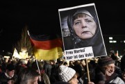 A protester holds a poster of German Chancellor Angela Merkel reading ‘Mrs. Merkel, here is the people’ during a rally of the Patriotic Europeans against the Islamization of the West (PEGIDA), Dresden, Germany, Jan. 12, 2015 (AP photo by Jens Meyer).