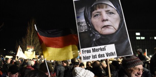 A protester holds a poster of German Chancellor Angela Merkel reading ‘Mrs. Merkel, here is the people’ during a rally of the Patriotic Europeans against the Islamization of the West (PEGIDA), Dresden, Germany, Jan. 12, 2015 (AP photo by Jens Meyer).