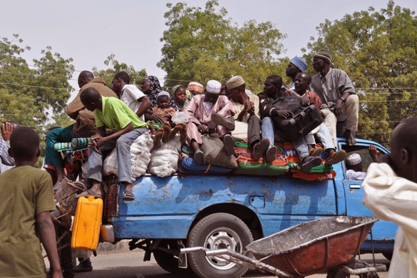 Villagers sitting on the back of a small truck as they, and others, flee the recent violence near the city of Maiduguri, Nigeria, Jan. 27, 2015 (AP photo by Jossy Ola).