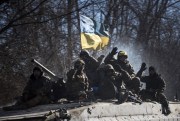 Ukrainian troops wave as they ride on an armored vehicle near Artemivsk, eastern Ukraine, Feb. 24, 2015 (AP photo by Evgeniy Maloletka).