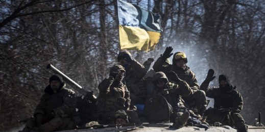 Ukrainian troops wave as they ride on an armored vehicle near Artemivsk, eastern Ukraine, Feb. 24, 2015 (AP photo by Evgeniy Maloletka).