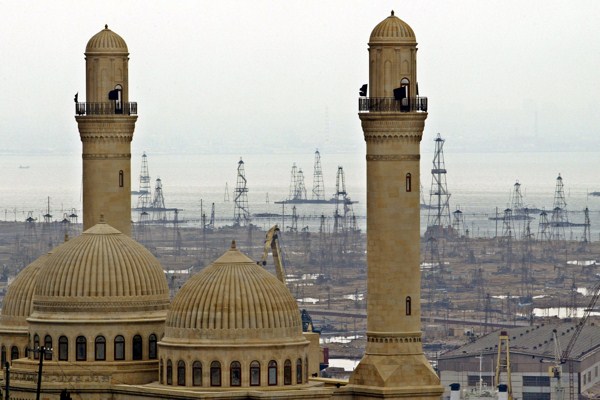 Oil derricks on the Caspian Sea beyond the Bibi Heybat Mosque in Baku, Azerbaijan, March 3, 2006 (AP photo by Mikhail Metzel).