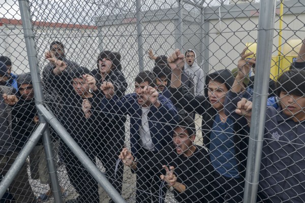 Migrants shout behind an iron fence at the Foreigners Detention Center in Amygdaleza, Greece, Feb. 14, 2015 (AP Photo/InTime News/Nikos Halkiopoulos).