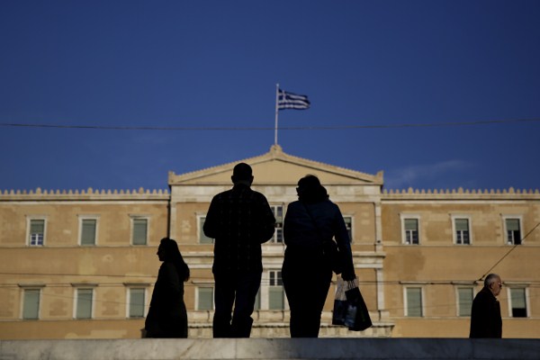 People walk past the Greek parliament in Athens, Greece, March 4, 2015 (AP photo by Petros Giannakouris).