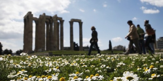 Tourist walk among flowers and the ancient Temple of Zeus, Athens, Greece, March 31, 2015 (AP photo by Petros Giannakouris).
