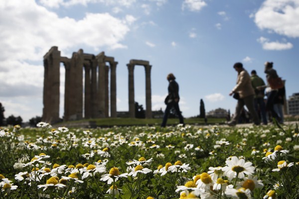 Tourist walk among flowers and the ancient Temple of Zeus, Athens, Greece, March 31, 2015 (AP photo by Petros Giannakouris).