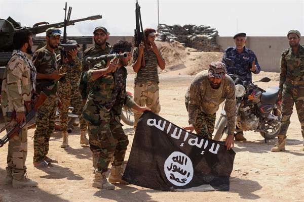 Iraqi security forces hold a flag of the Islamic State group they captured during an operation outside Amirli, north of Baghdad, Iraq, Oct. 7, 2014 (AP file photo).
