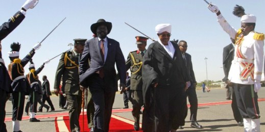 Sudanese President Omar al-Bashir walks with South Sudan President Salva Kiir on arrival in Khartoum, Nov. 4, 2014 (AP photo by Abd Raouf).