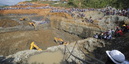 People watch machinery used to dig in search or survivors at a collapsed illegal gold mine in Santander de Quilichao, southern Colombia, May 1, 2014 (AP Photo/Oswaldo Paez, El Pais).