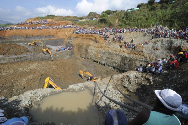 People watch machinery used to dig in search or survivors at a collapsed illegal gold mine in Santander de Quilichao, southern Colombia, May 1, 2014 (AP Photo/Oswaldo Paez, El Pais).