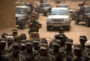 A French soldier stands watch behind Malian soldiers during a visit by the head of France's Operation Serval and Mali’s army chief of staff to a Malian army base, Kidal, Mali, July 27, 2013 (AP photo by Rebecca Blackwell).