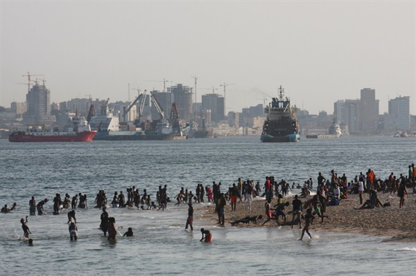 Angolans at the beach in front of the capital skyline, marked by new construction, Luanda, Angola, March 8, 2010 (photo by Flickr user mp3ief, licensed under Creative Commons Attribution-NonCommercial-ShareAlike 2.0 Generic license).