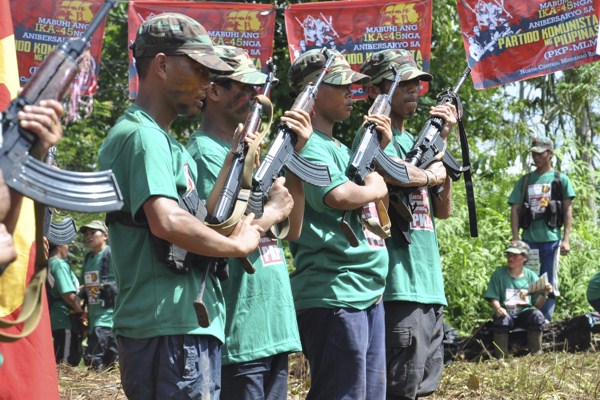 Communist New People’s Army (NPA) rebels hold weapons in formation in the hinterlands of Davao, Philippines, Dec. 26, 2013 (AP photo).