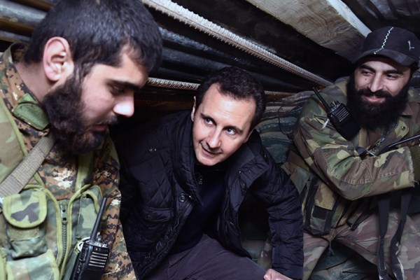 Syrian President Bashar al-Assad speaks with Syrian troops during his visit to the front line in the eastern Damascus district of Jobar, Syria, Dec. 31, 2014 (AP Photo/SANA).