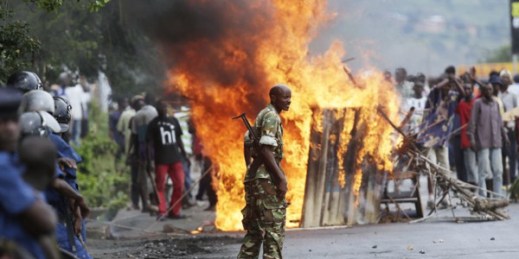 A soldier stands between demonstrators and riot police facing off in the Musaga district of Bujumbura, Burundi, May 4, 2015 (AP photo by Jerome Delay).